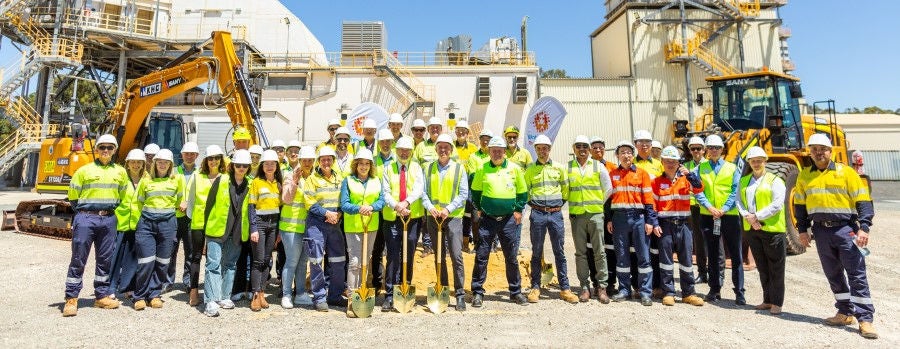 Attendees in hi-vis and hard hats gathers at Wagerup for a group photo
