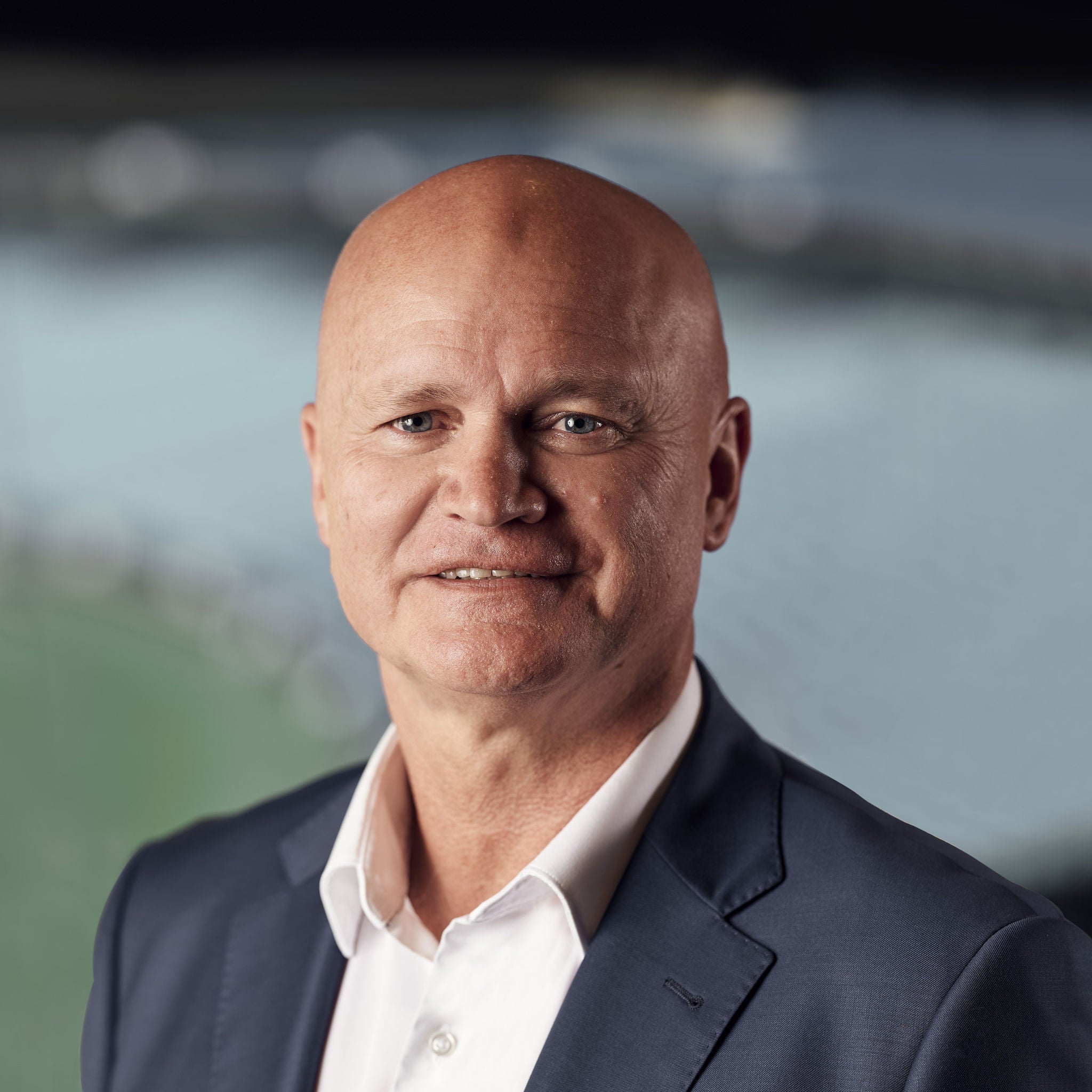 A portrait shot of Alinta Energy Executive Director Ken Woolley wearing a grey suit and white shirt.