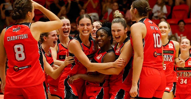 Perth Lynx basketball players hugging each other and celebrating