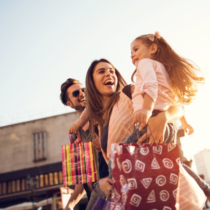 Family laughing with shopping bags
