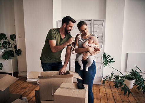 Young family with baby and packing boxes