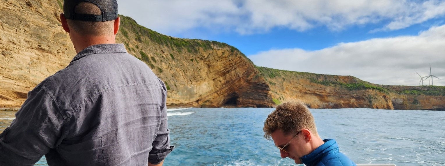 Spinifex Project Team members sit on a boat offshore Portland