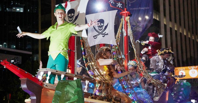 Peter Pan themed float showing Peter Pan with various fairies and Captain Hook surrounding by flags and lights