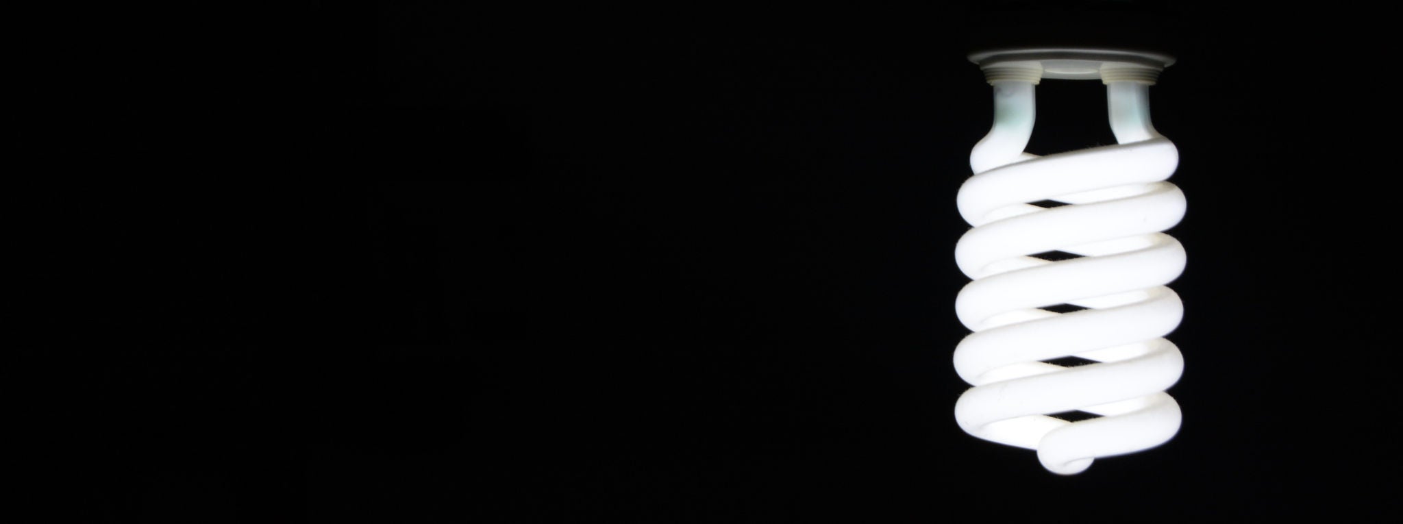 An energy-saving lightbulb against a black background