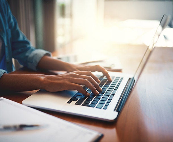 Close up of woman typing on laptop keyboard
