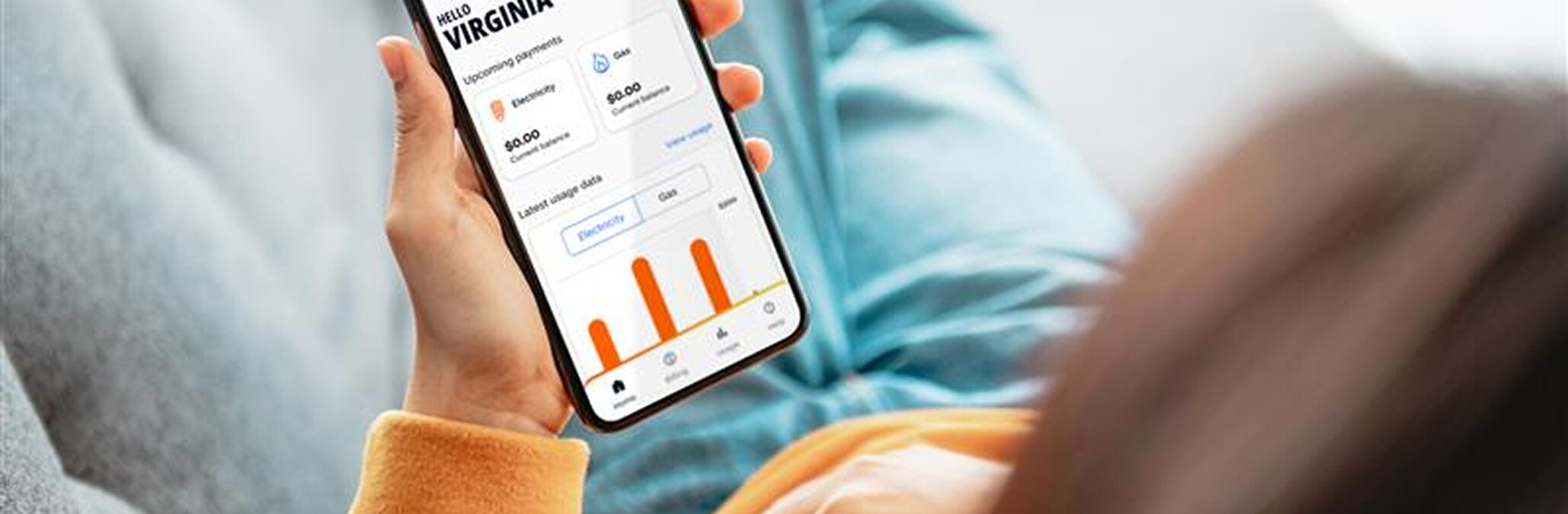 A close shot of a woman looking at her mobile phone and checking out the Alinta Energy app