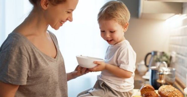 Mother and toddler cooking together and smiling