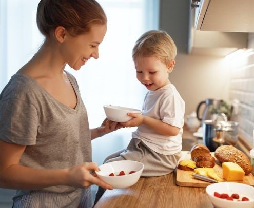 Mother and toddler cooking together and smiling