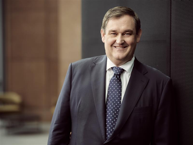 A picture of Alinta Energy CEO and Managing Director Jeff Dimery smiling. He is wearing a grey suit and blue tie with white dots.