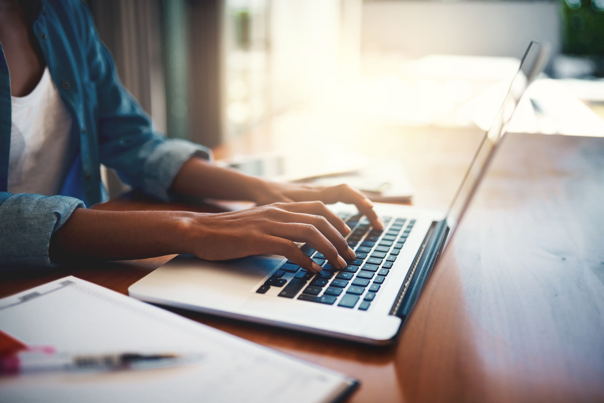 Closeup shot of woman using a laptop while working from home