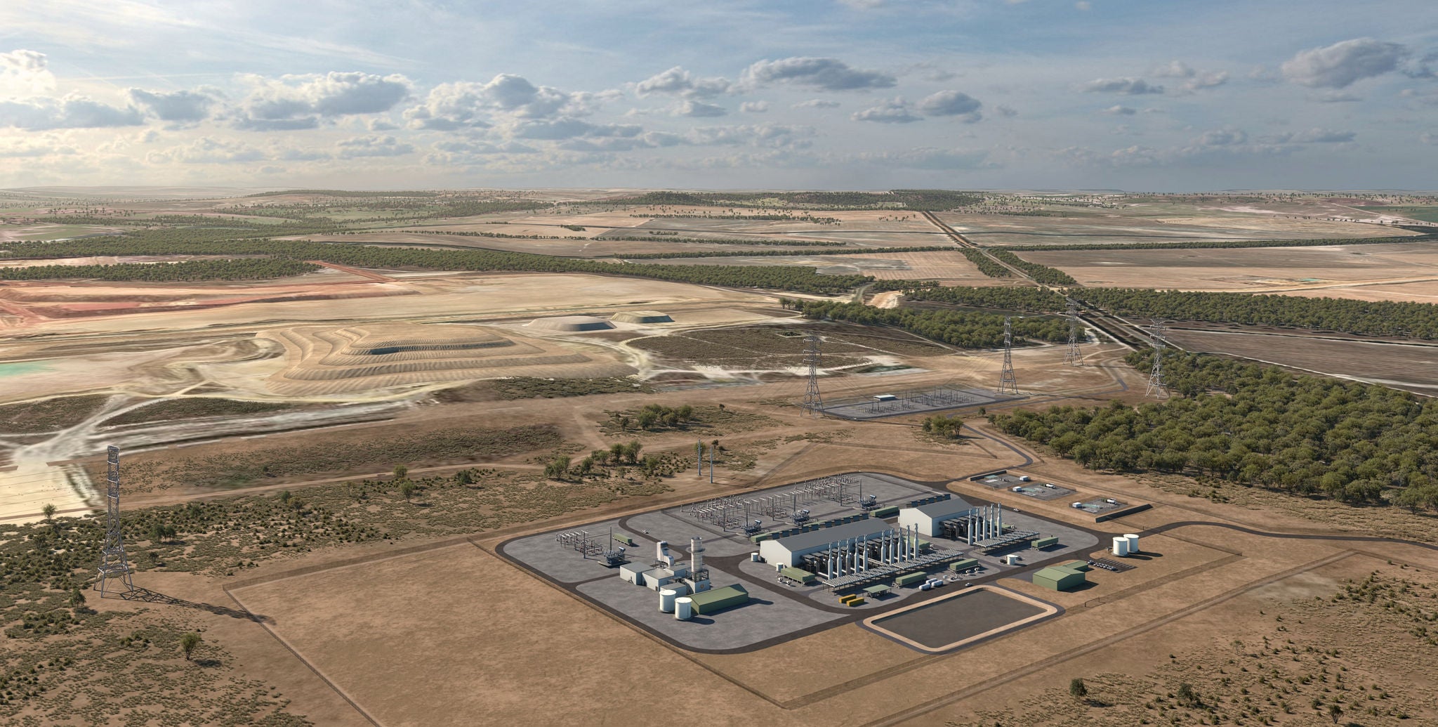 Aerial view of two large LNG storage tanks connected by pipework within an industrial processing facility, surrounded by roads and infrastructure in a desert landscape.