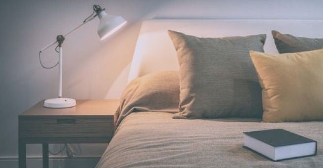 An illuminated lamp on a bedside table