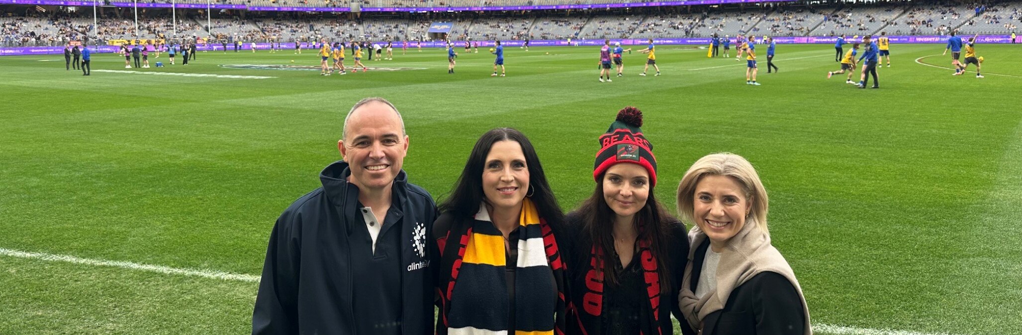 Alinta team with Bayswater FC reps at the Optus Stadium with AFL players behind